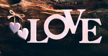 Wooden letters forming word LOVE written on wooden background. St. Valentine's Day. two heartsの写真素材
