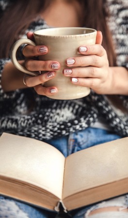 girl having a break with cup of fresh coffee after reading books or studyingの写真素材