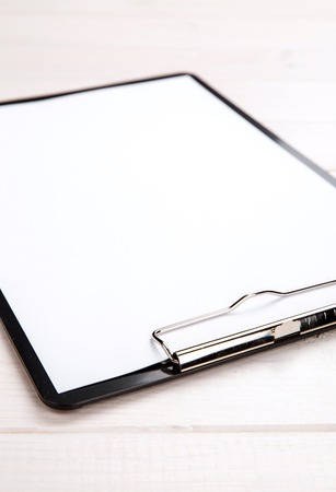 Clipboard on the wooden background