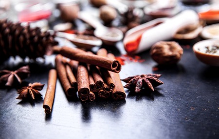 wooden spoons with spices on black backgroundの写真素材