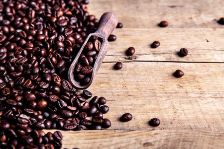Coffee beans in wooden spoon, close upの写真素材