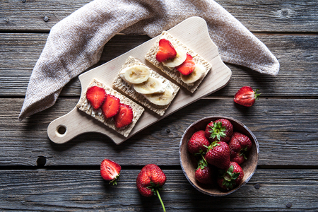 Fruity toast on wooden background. Strawberries, bread, butter and cheese.Vintage styleの写真素材