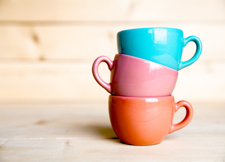 Colored cups on the wooden backgroundの写真素材