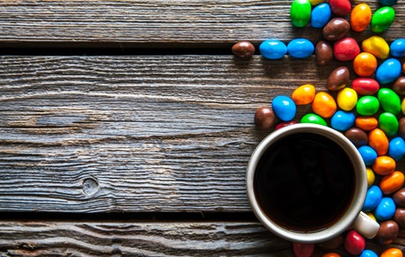colored sweets with coffee on a wooden backgroundの写真素材
