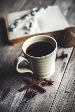Large Cup of coffee on vintage wooden background. Spring flowers and books.の写真素材