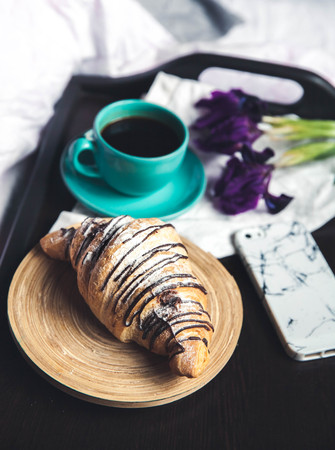 Breakfast in bed. Morning, croissant, coffee, flowers and a notebook with a pen. Planningの写真素材