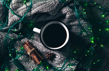 Christmas and garlands. Winter cozy concept. Flatlay of gray knitted sweater. Warm weekend in cold weather.の写真素材
