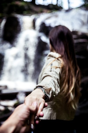 The girl leads her boyfriend to a beautiful waterfall. Nature aの写真素材