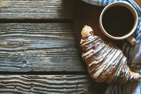 Cup of espresso coffee and croissant in turquoise blue ceramic tray over grey concrete background, selective focus, copy spaceの写真素材