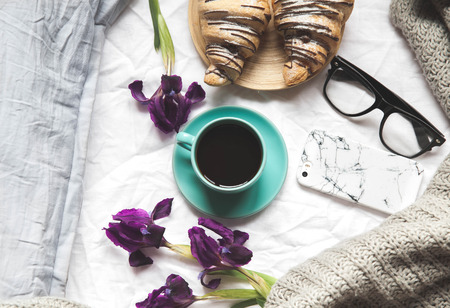 Breakfast in bed. Morning, croissant, coffee, flowers and a notebook with a pen. Planning aの写真素材