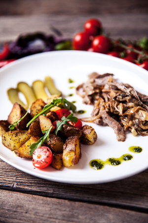 Meat in a sauce of white mushrooms and fried potatoes. Food aの写真素材