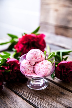 ice cream and peony flower as symbol of summer and holiday on wood background aの写真素材