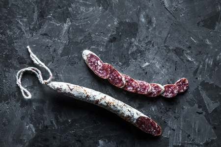 Slices of french saucisson salami on a greyの写真素材