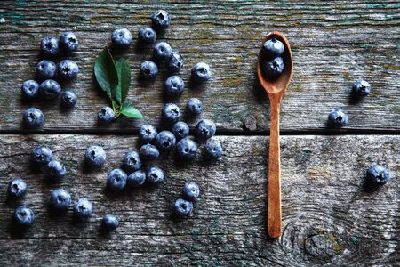 Fresh blueberries in a wooden spoon over wooden tableの写真素材