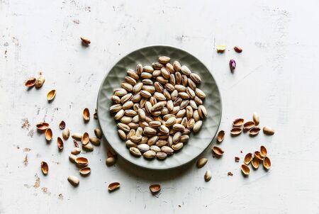 Salted pistachios on a gray plate