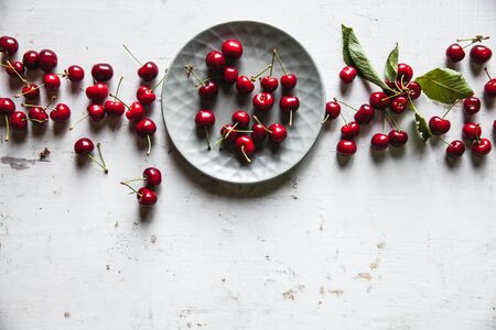 Sweet cherries in a plate on an old whiteの写真素材