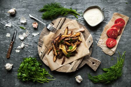 Tasty french fries on cutting board, on wooden table