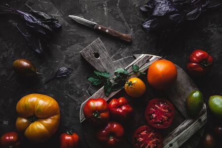 Composition with delicious tomatoes, wooden board and products on greyの写真素材