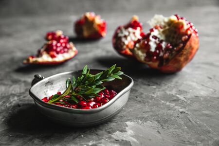 Food photo of red ripe pomegranate pieces in bowl on the gray table with copy space. Healthy food, fruit, diet conceptの写真素材