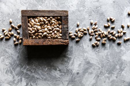 Pistachios nuts in wooden box. Top viewの写真素材