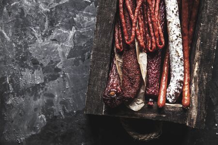 Salami with spices in an old tray. On a dark gray backgroundの写真素材