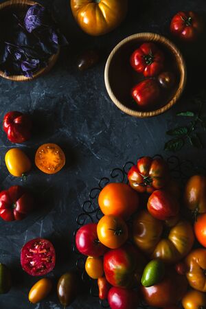 Composition with delicious tomatoes, wooden board and products on grey background, healthy food, vegetablesの写真素材