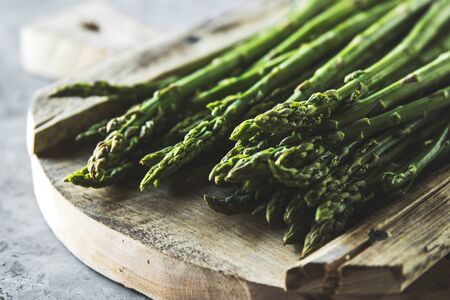 Tasty asparagus on a sliced old boardの写真素材