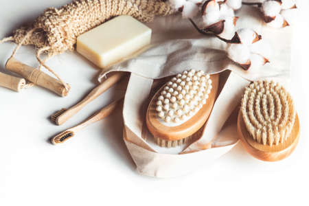 Natural brushes made of wood and soap on the background of concrete, bamboo toothbrushes and body...