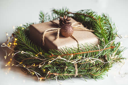 Gift in craft paper in a wreath of Christmas trees. Christmas mood, New Year, On white background