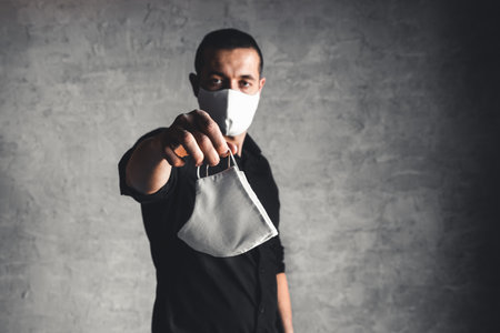 Epidemiologist offering protective respiratory mask in coronavirus concept, selective focusの写真素材
