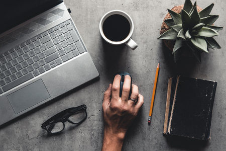 The office desk flat lay view with laptop, mouse, tree, paper clip, coffee cup, notebook, pencil, black glasses on white background.の写真素材