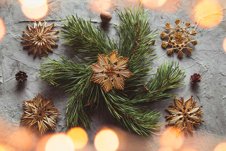 Homemade straw decor on Christmas tree close up. on a gray concrete background.の写真素材