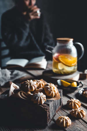 Woman is reading and Hot tea with fresh grapefruit on wooden tablet. Healthy drink, Eco, vegan.の写真素材