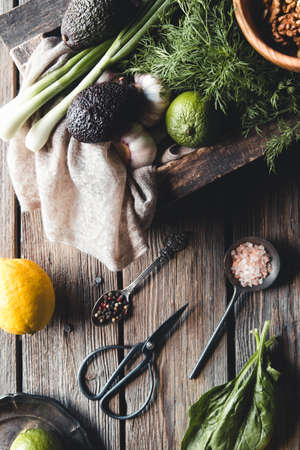 Culinary green herbs, spinach, dill, parsley, avocado in a wooden box isolated on white backgroundの写真素材