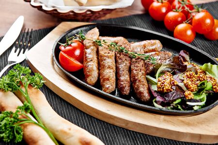 Beef sausages with vegetables on a hot panの写真素材