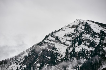 High mountains in the clouds with snowの写真素材