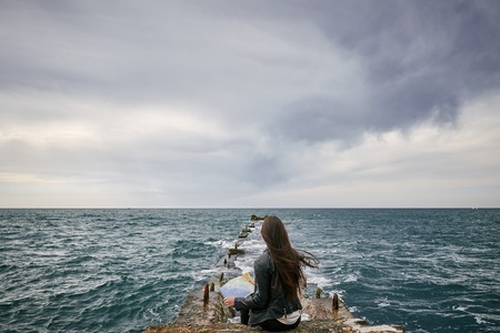 Woman on the pier watching big map.