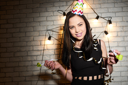 Woman enjoys the holiday on the brick wall background. Birthday. New Year.の写真素材