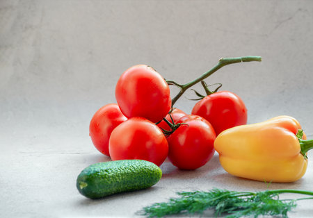 Tomato branch, cucumber and yellow pepper on bright backgroundの写真素材