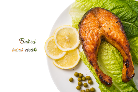 Top view of a baked trout steak with lemon and lettuce. Space for textの写真素材