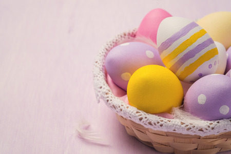 Easter eggs in a wicker basket with space for textの写真素材