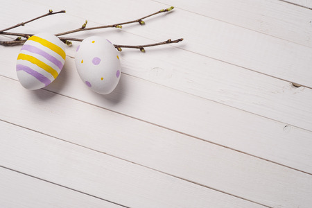 Colorful Easter eggs with branches of cherry on a background of painted wood and place for textの写真素材