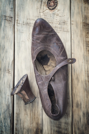 Old worn shoes on a wooden table. Top viewの写真素材