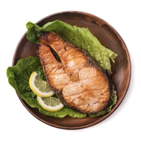 Baked steak trout with lemon and salad on white background. Top viewの写真素材