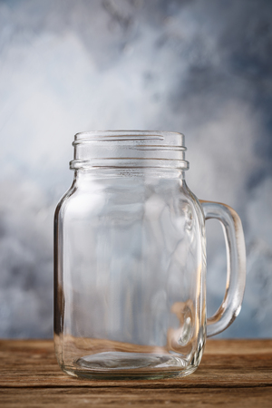 Empty glass jar on a wooden table, close-upの写真素材