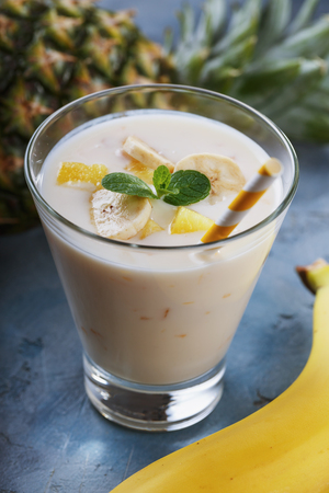 Glass of yogurt with pieces of banana and pineapple, close-upの写真素材