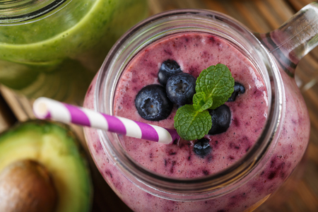 Smoothies of blueberry, banana and orange in a glass jar top view, close-upの写真素材