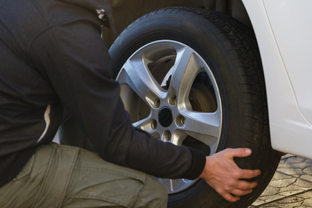 Man is changing a wheel in a car, close-upの写真素材