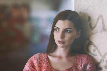 Portrait of a young beautiful girl near a wall close-upの写真素材