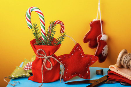 Christmas decorations and gifts made by own hands. Festive toys on colored backgroundの写真素材
